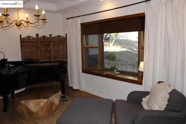 a living room with furniture a chandelier and a flat screen tv