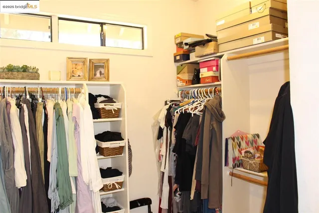 a view of a hallway with wooden floor and a bathroom