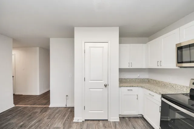 a kitchen with a refrigerator stove and white cabinets
