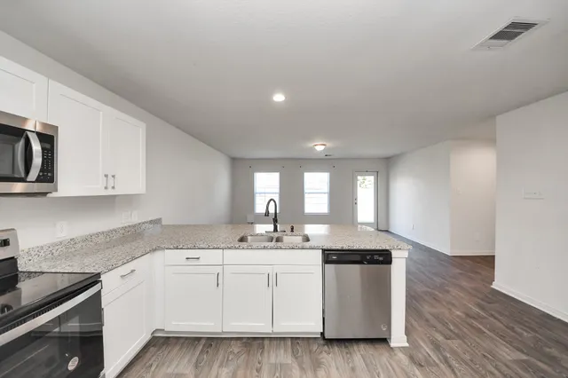 a kitchen with a sink window and cabinets