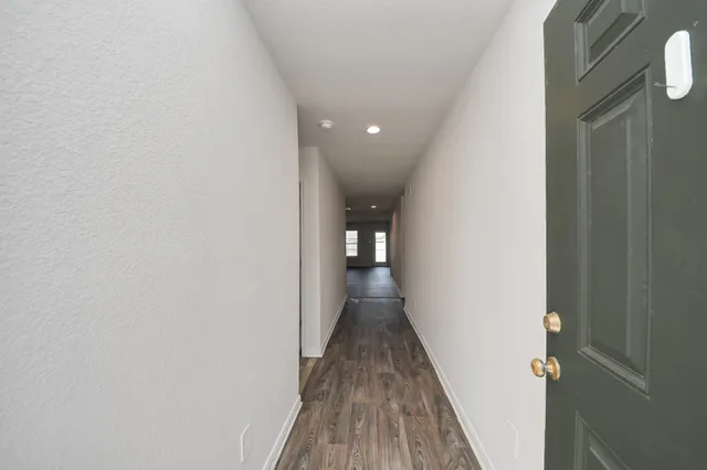 a view of a hallway with wooden floor