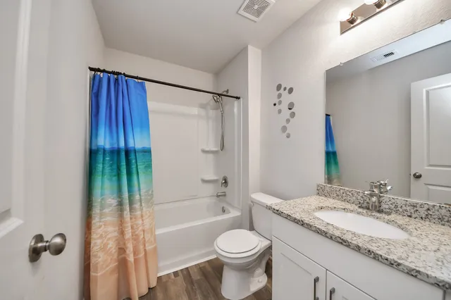 a bathroom with a granite countertop sink toilet and shower