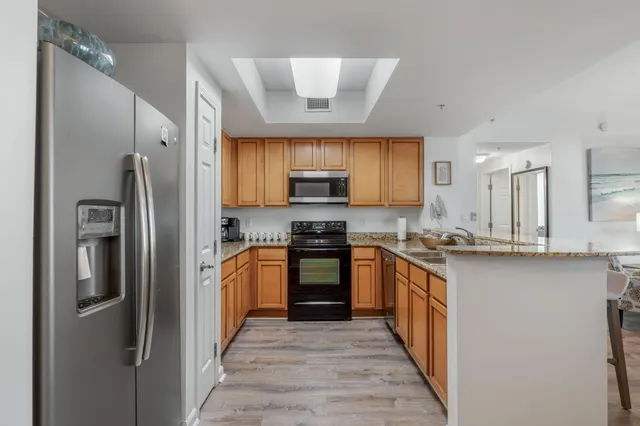 a kitchen with stainless steel appliances granite countertop a refrigerator and a stove top oven