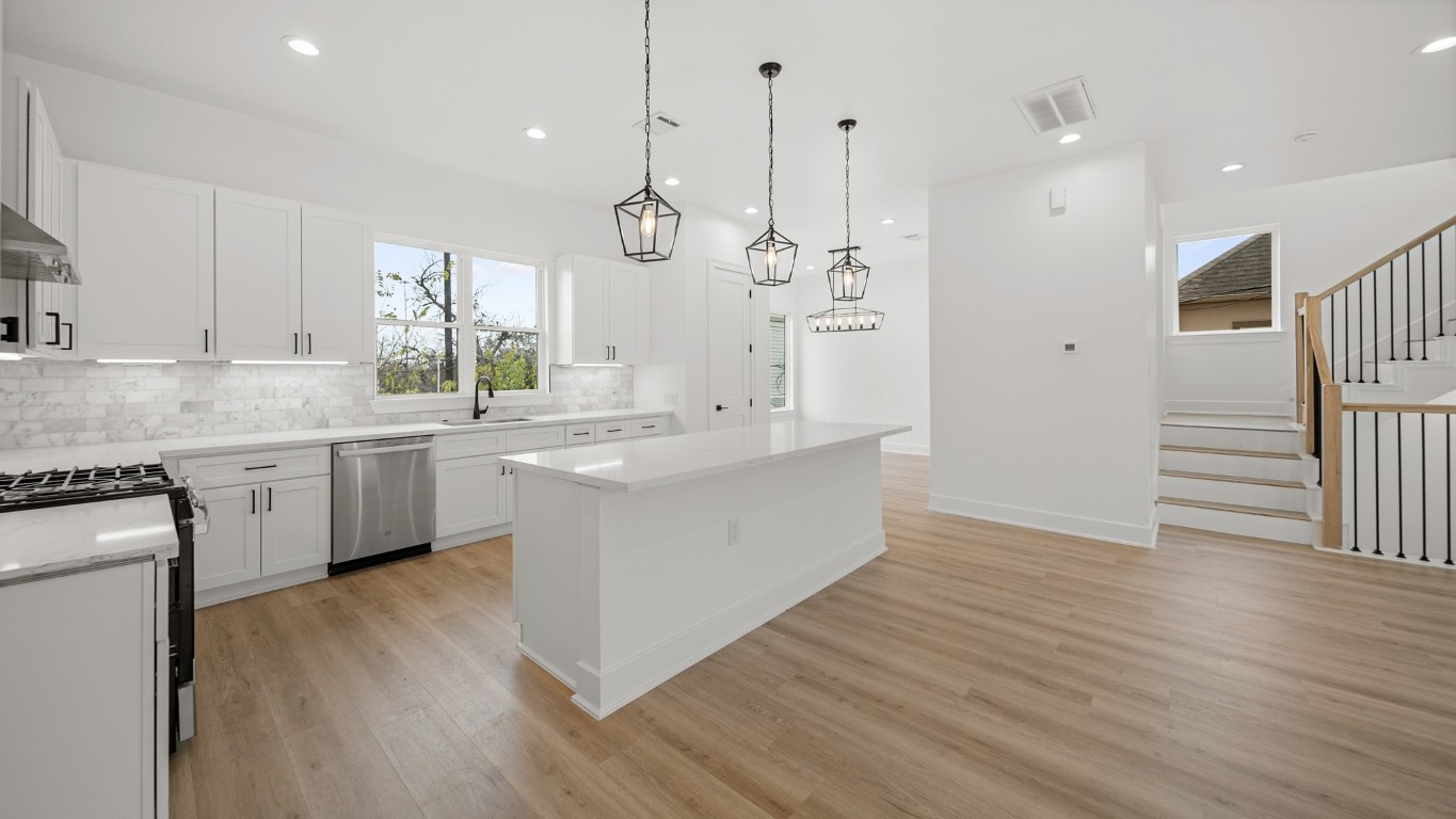 1908 Wheeler Avenue Houston, TX 77004 - Photo 22 of 43 a large white kitchen with a refrigerator a sink dishwasher a stove and white cabinets with wooden floor