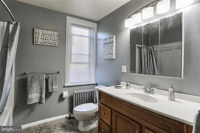a bathroom with a granite countertop sink toilet a mirror and shower
