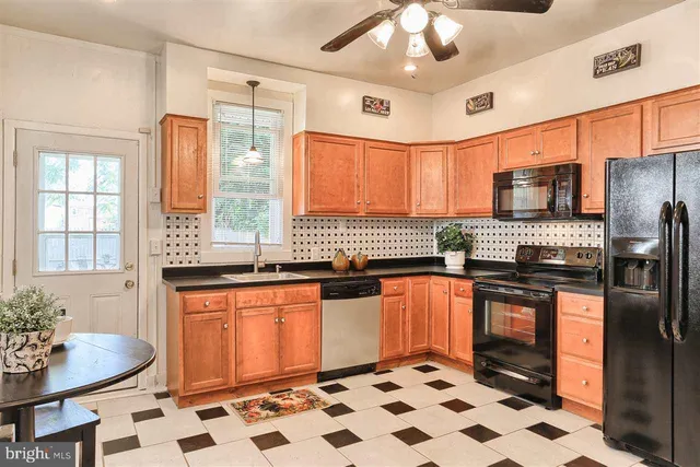 a kitchen with stainless steel appliances granite countertop a sink a stove a refrigerator cabinets and dining table