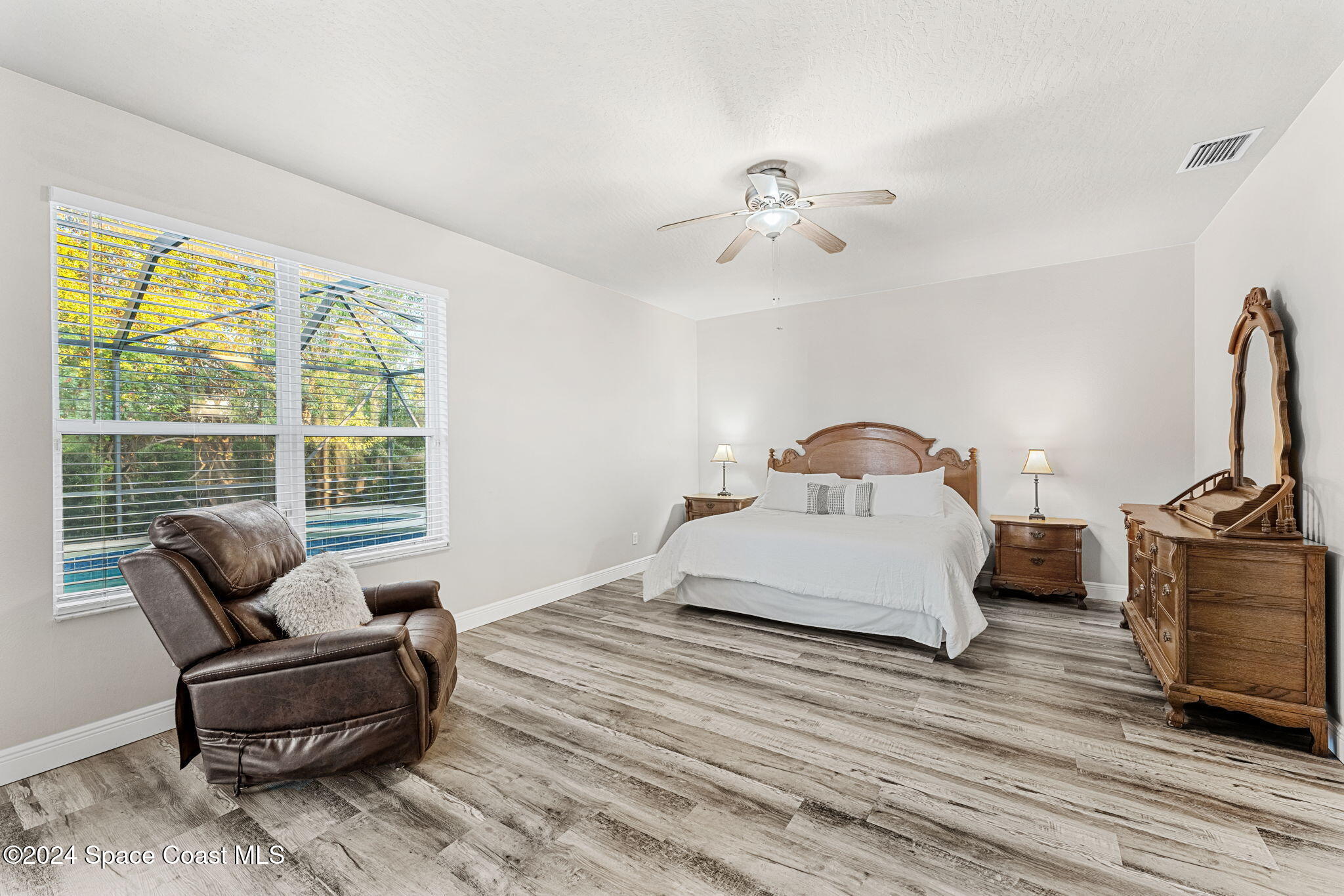 3416 Peninsula Circle Melbourne, FL 32940 - Photo 20 of 61 a bedroom with a bed and wooden floor