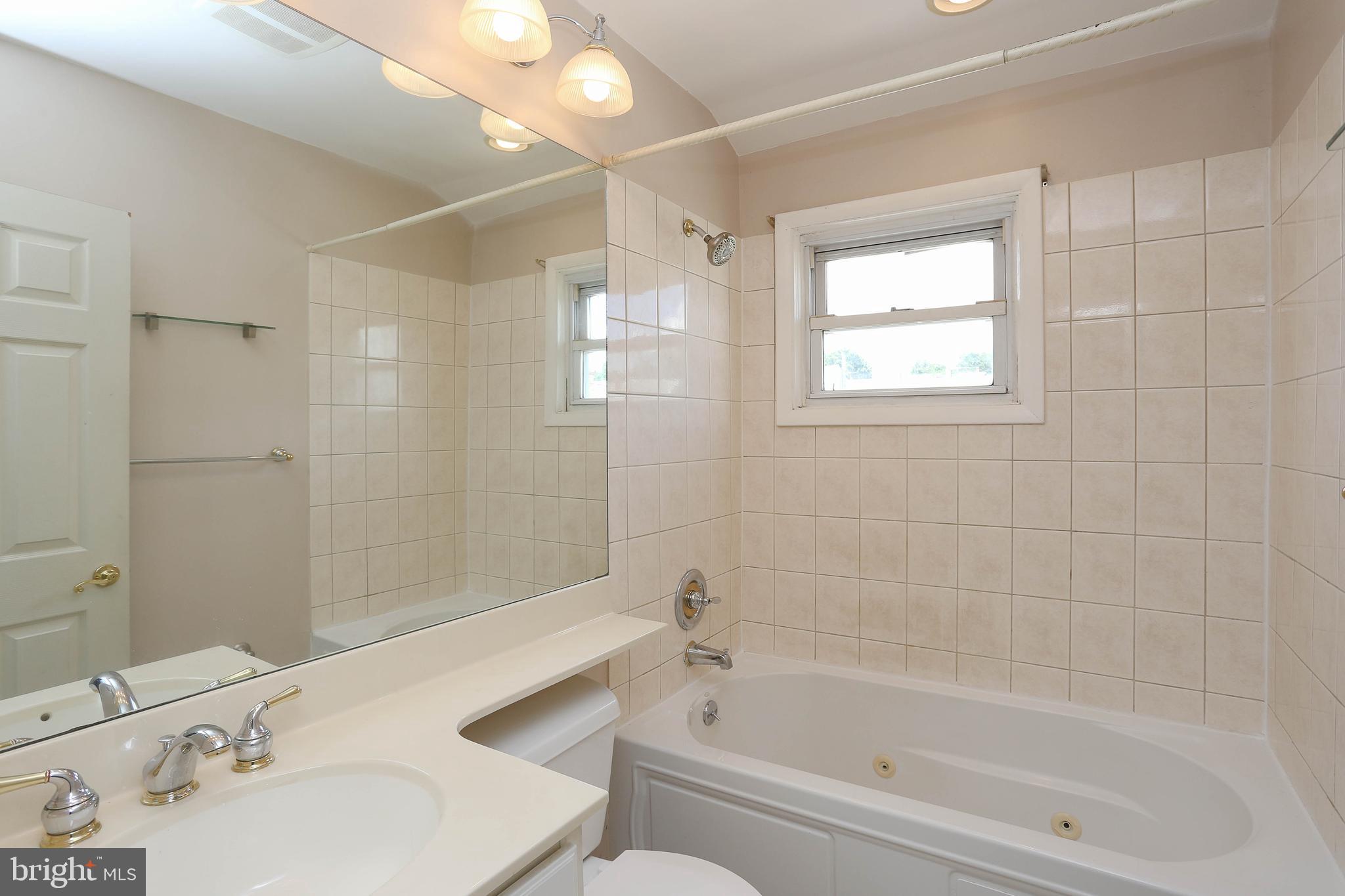 4446 Norfen Road Halethorpe, MD 21227 - Photo 22 of 37 a bathroom with a bathtub shower sink vanity and toilet