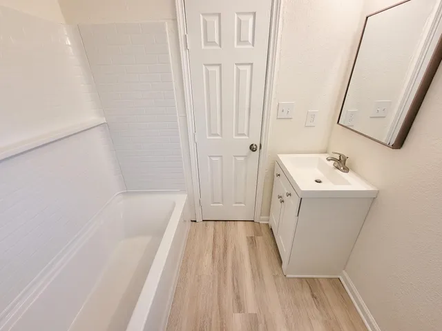 a bathroom with a sink a window and a shower