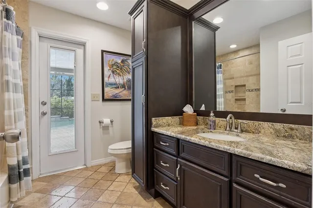 a bathroom with a granite countertop sink toilet and shower