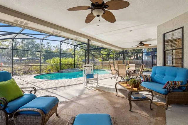 a living room with patio furniture and a floor to ceiling window