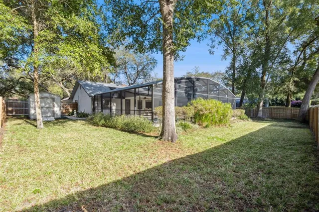 a view of a house with a yard and tree s