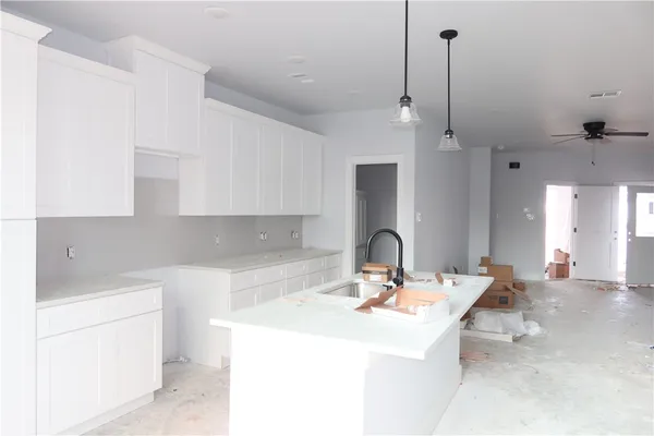 a kitchen with a sink a counter and a living room view