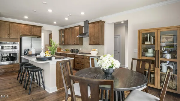 a kitchen with stainless steel appliances granite countertop a dining table chairs and granite counter tops