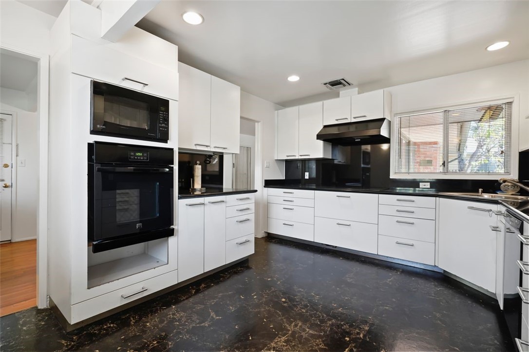 14335 Aztec Street Sylmar, CA 91342 - Photo 22 of 48 a kitchen with stainless steel appliances kitchen island granite countertop a stove a sink and a microwave