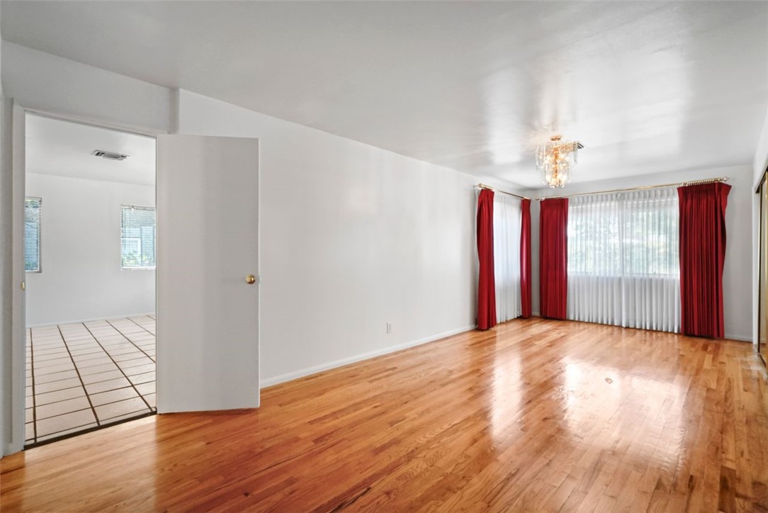 14335 Aztec Street Sylmar, CA 91342 - Photo 27 of 48 a view of a room with wooden floor and a chandelier