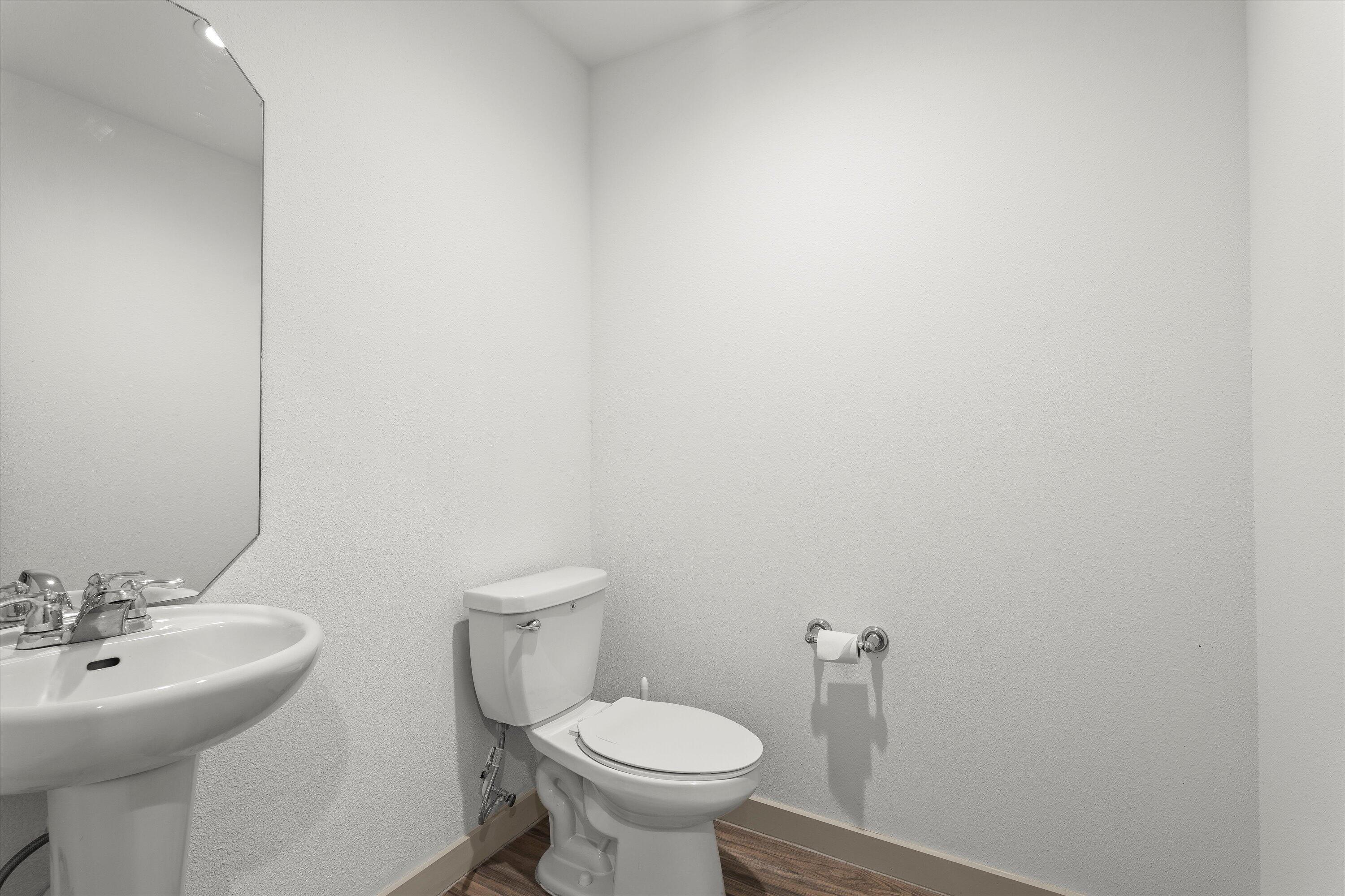 7416 9th Street Lubbock, TX 79416 - Photo 22 of 34 a bathroom with a sink a toilet and a mirror