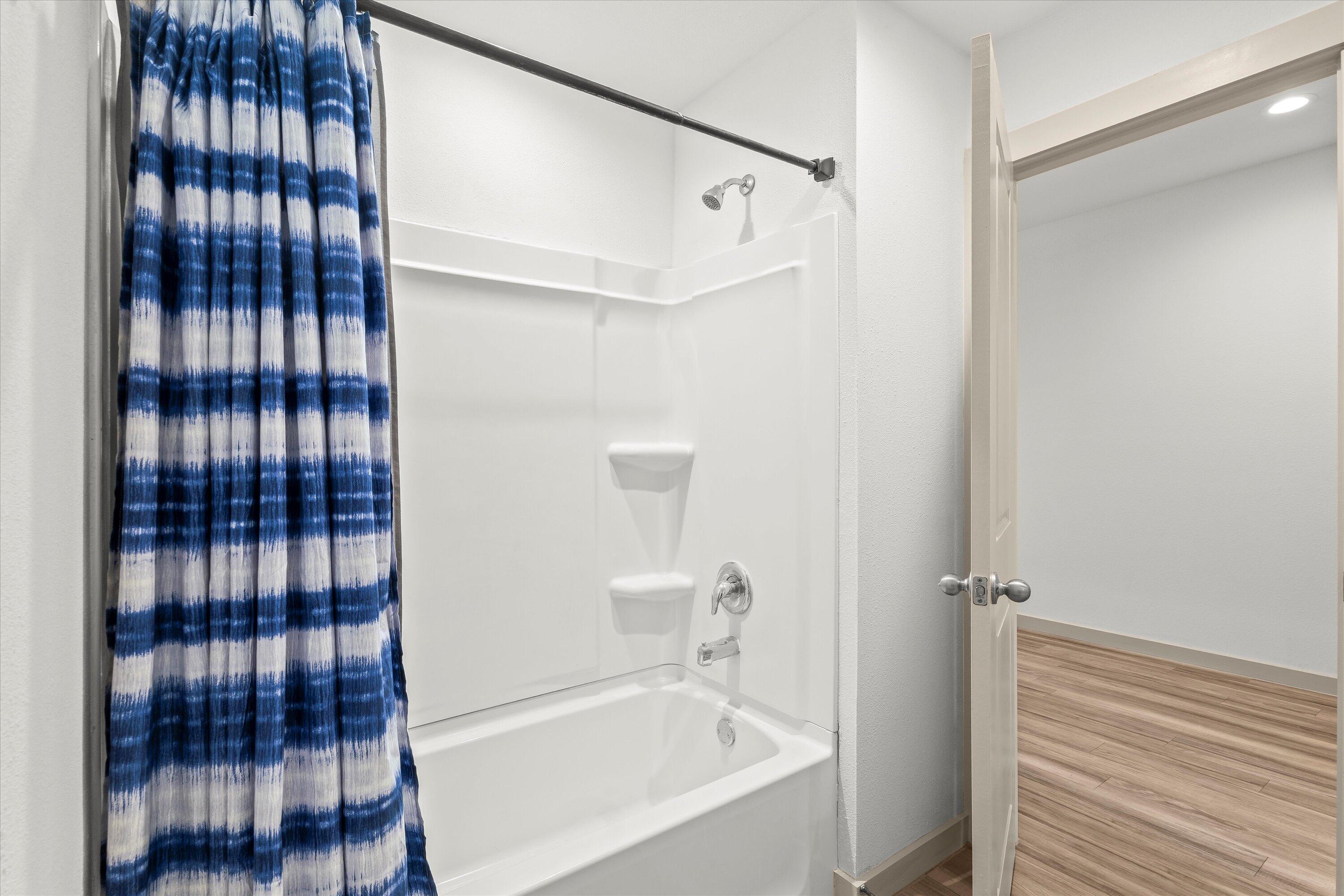 7416 9th Street Lubbock, TX 79416 - Photo 26 of 34 a bathroom with a bathtub and a shower