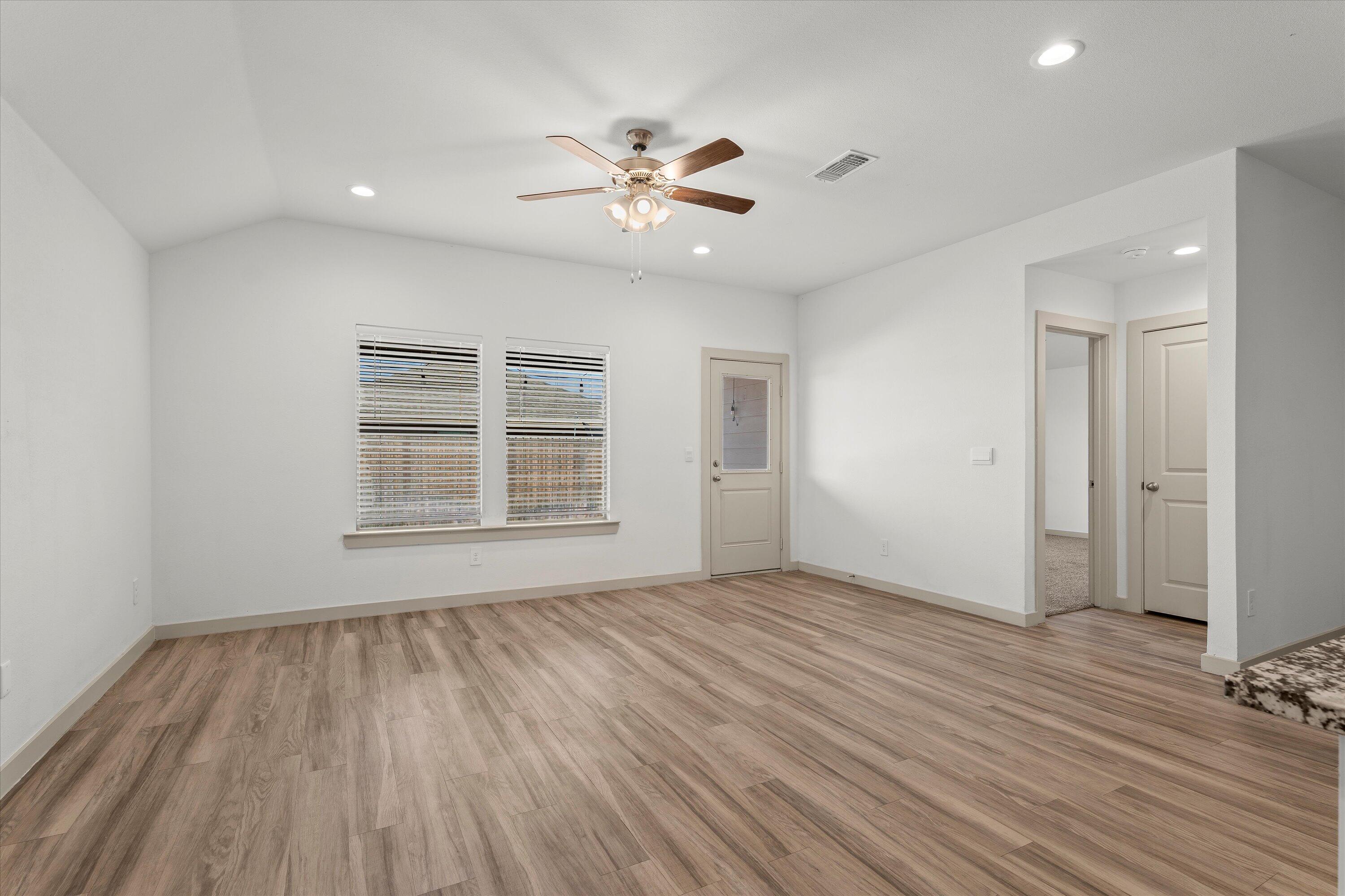 7416 9th Street Lubbock, TX 79416 - Photo 7 of 31 a view of an empty room with wooden floor and a window