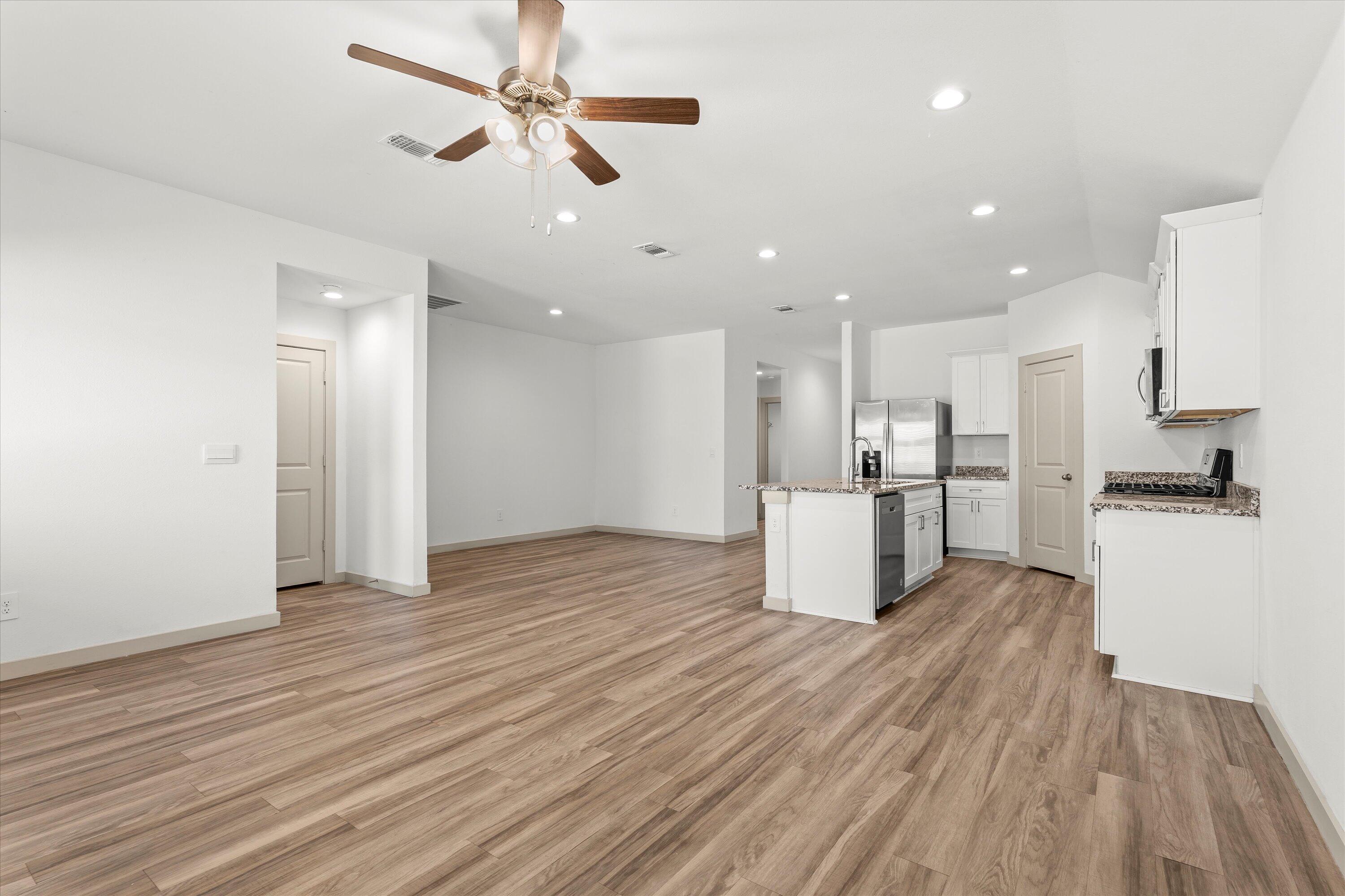 7416 9th Street Lubbock, TX 79416 - Photo 7 of 34 a view of kitchen with stainless steel appliances refrigerator wooden floor and window