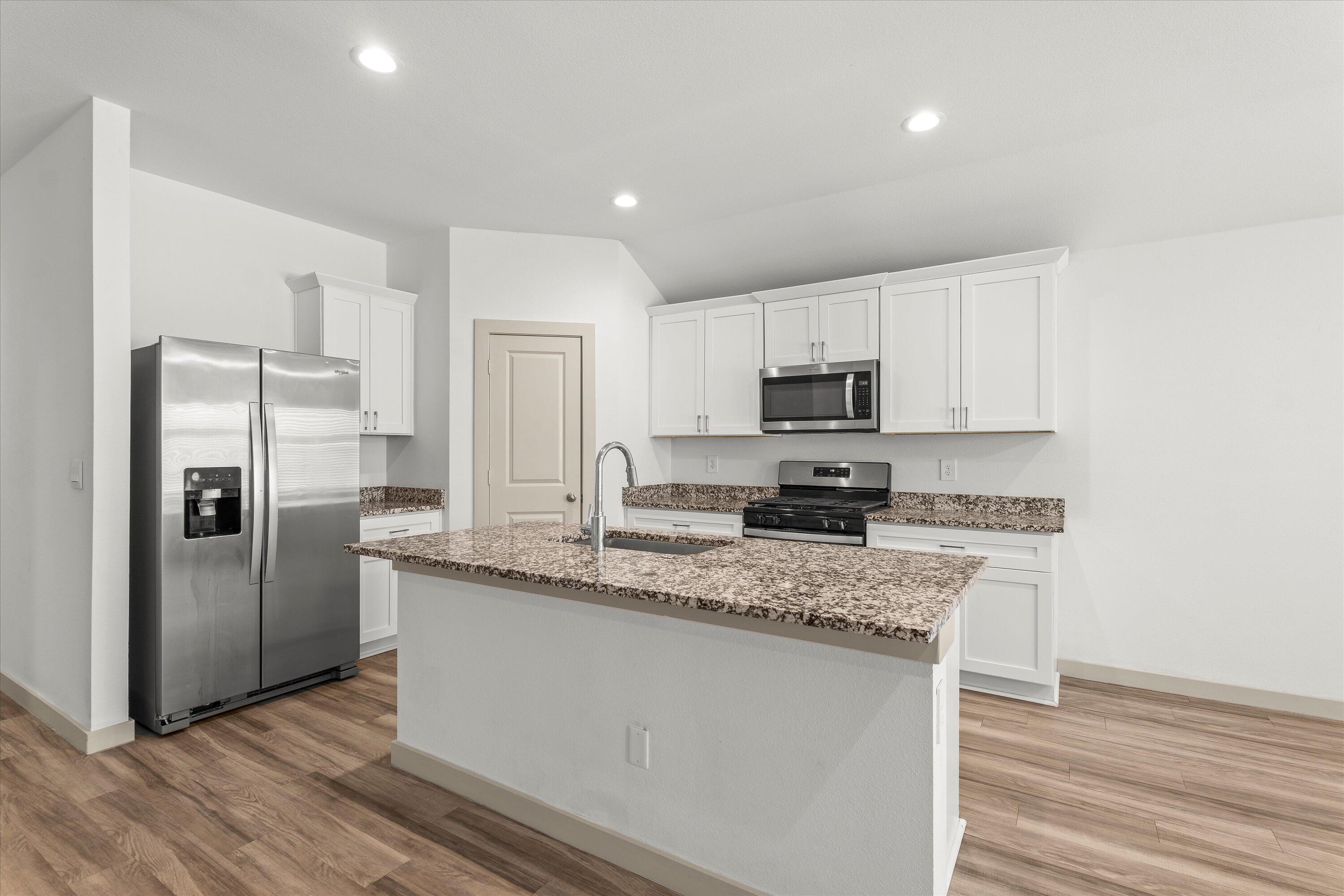 7416 9th Street Lubbock, TX 79416 - Photo 10 of 34 a kitchen with stainless steel appliances granite countertop a refrigerator a stove a sink and a microwave