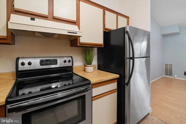 a metallic refrigerator freezer sitting in a kitchen