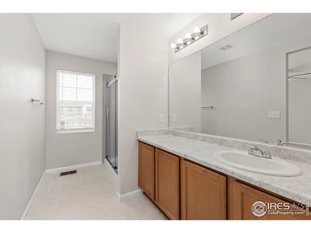 a bathroom with a sink double vanity granite and a mirror