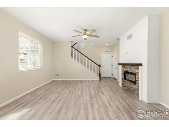 a view of empty room with fireplace and wooden floor