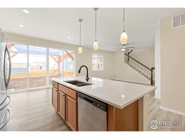 a kitchen with a sink a counter space and a view of living room