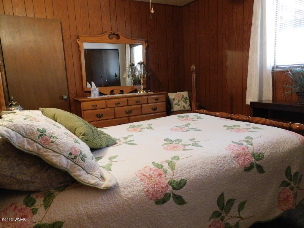 2021 Lumber Valley Road Overgaard, AZ 85933 - Photo 18 of 39 a bedroom with a bed and a mirror