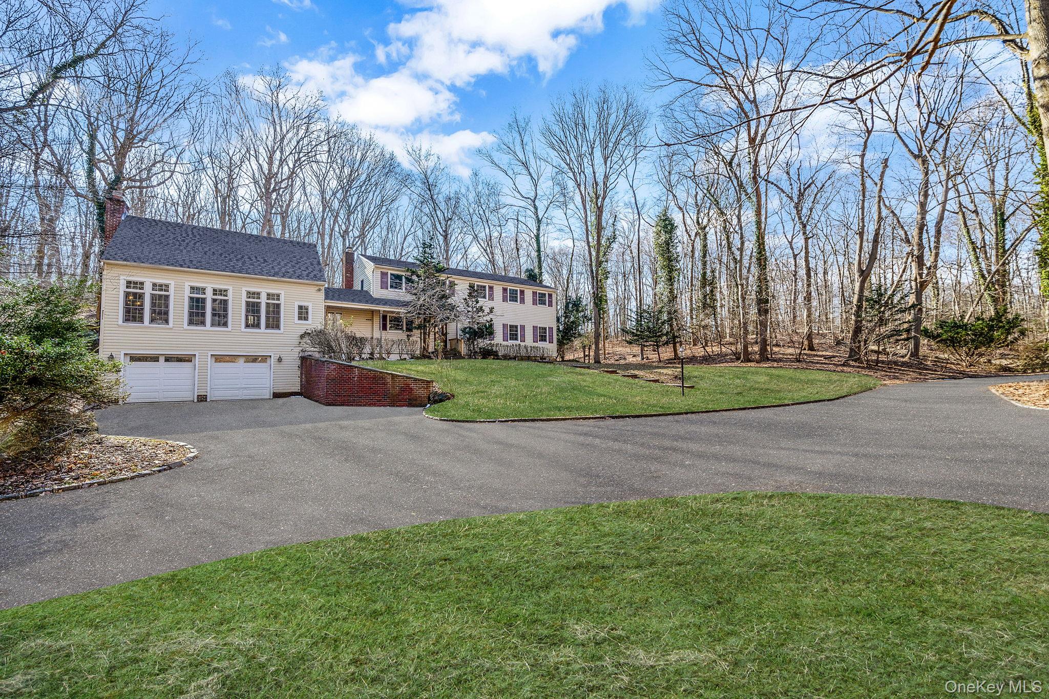 a front view of a house with a yard and trees