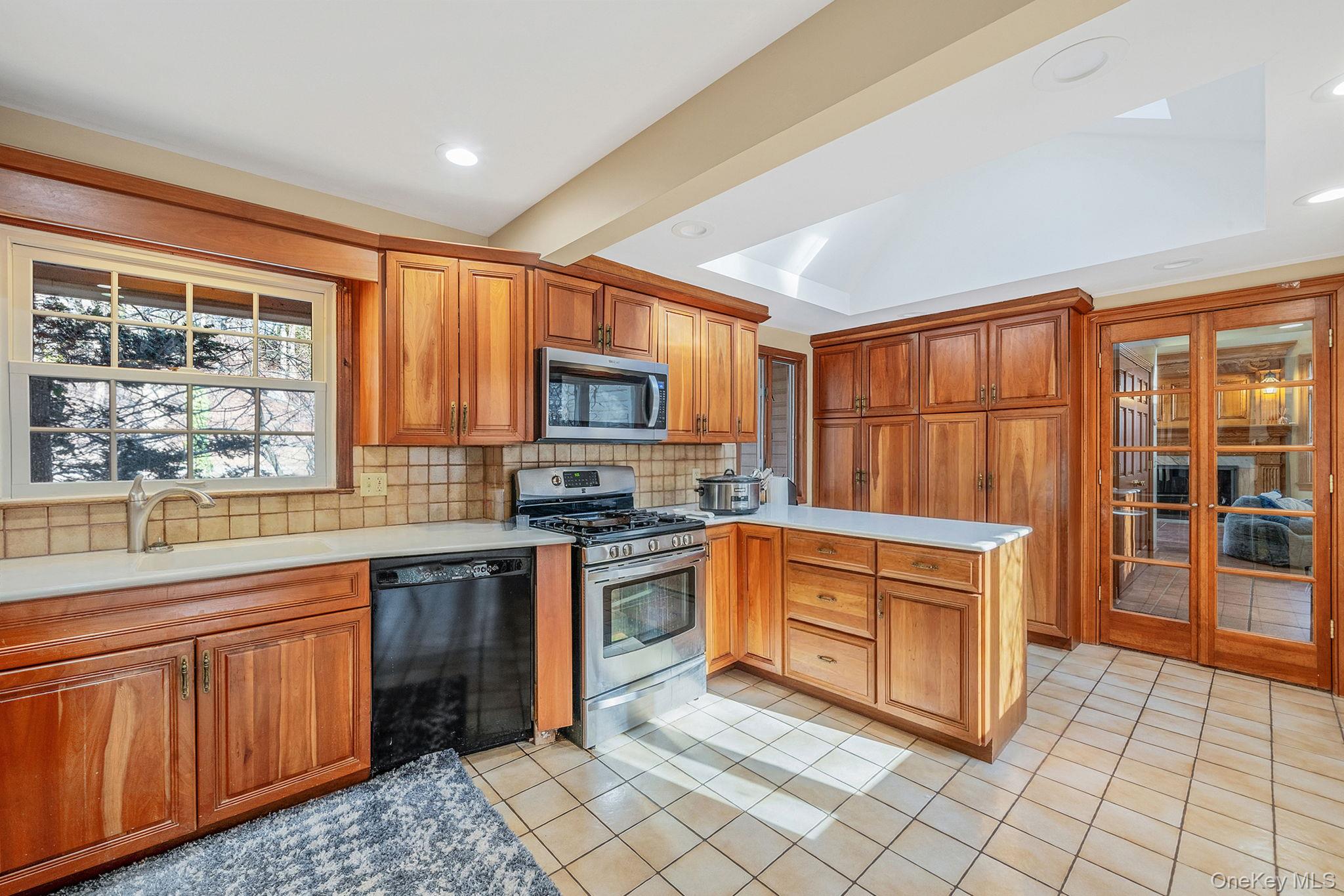 1 Spring Hollow Road Nissequogue, NY 11780 - Photo 4 of 17 a kitchen with stainless steel appliances granite countertop a stove top oven a sink dishwasher a dining table and chairs with wooden floor
