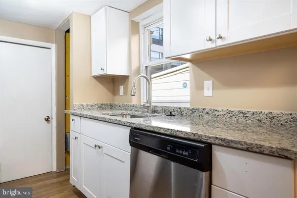a kitchen with granite countertop cabinets sink and window