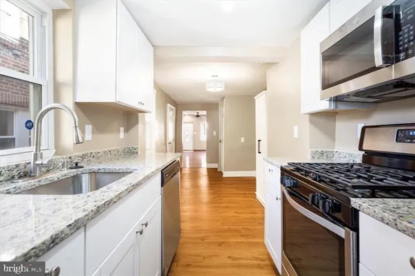 a kitchen with stainless steel appliances granite countertop a sink stove and cabinets