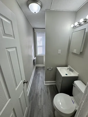a bathroom with a toilet sink and mirror