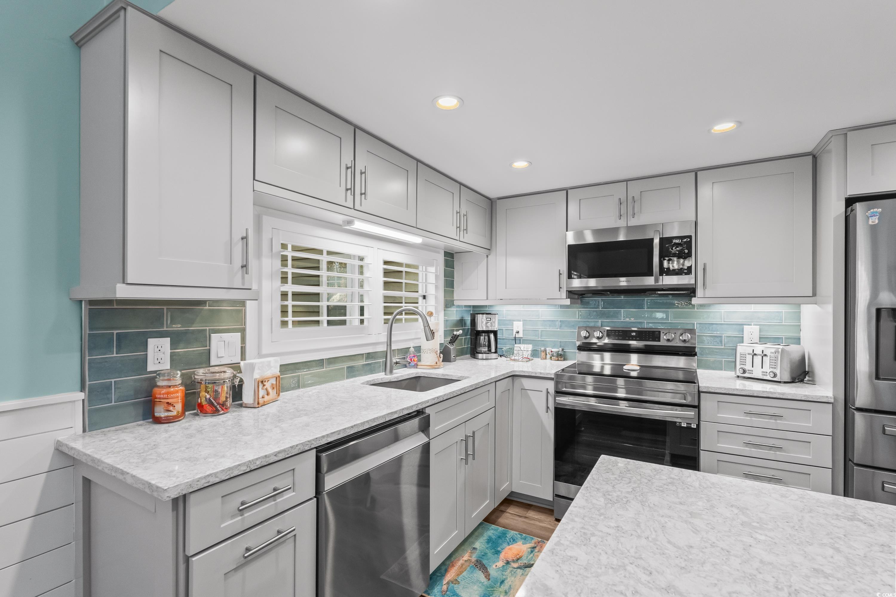 304 Cumberland Terrace, Unit 2F Myrtle Beach, SC 29572 - Photo 13 of 40 Kitchen featuring gray cabinets, appliances with stainless steel finishes, decorative backsplash, and recessed lighting