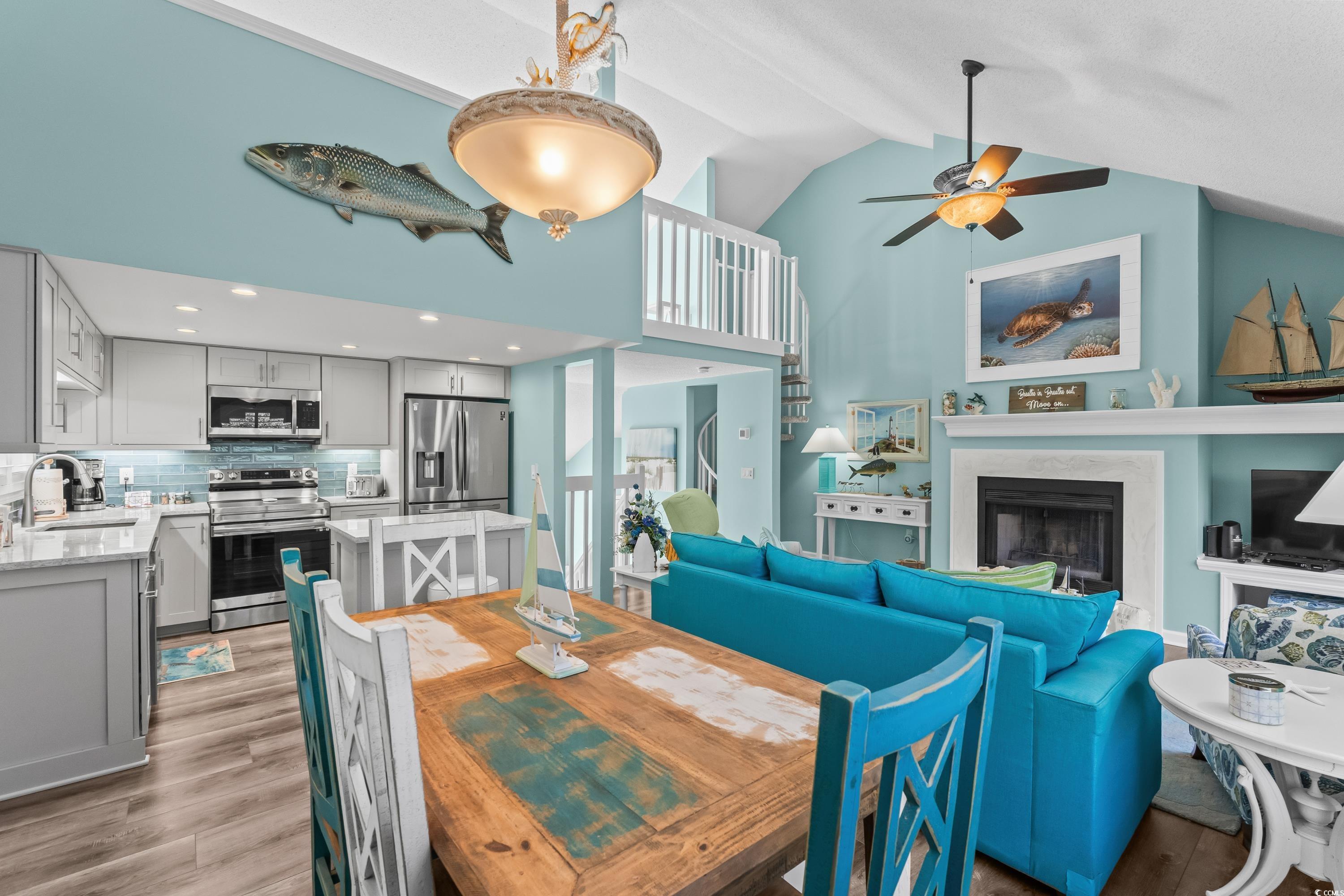 304 Cumberland Terrace, Unit 2F Myrtle Beach, SC 29572 - Photo 18 of 40 Dining space with a high end fireplace, light wood-style flooring, a ceiling fan, and high vaulted ceiling