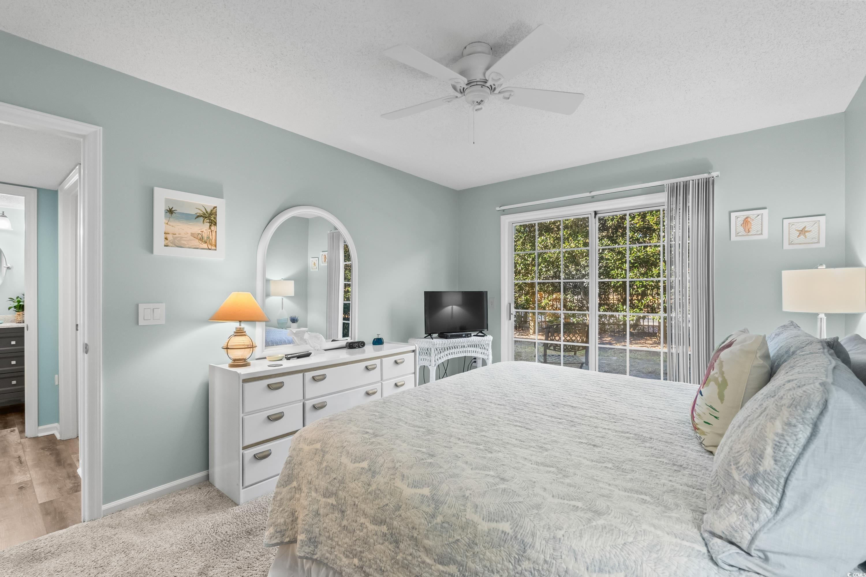 304 Cumberland Terrace, Unit 2F Myrtle Beach, SC 29572 - Photo 23 of 40 Bedroom with light colored carpet, ceiling fan, access to outside, and a textured ceiling