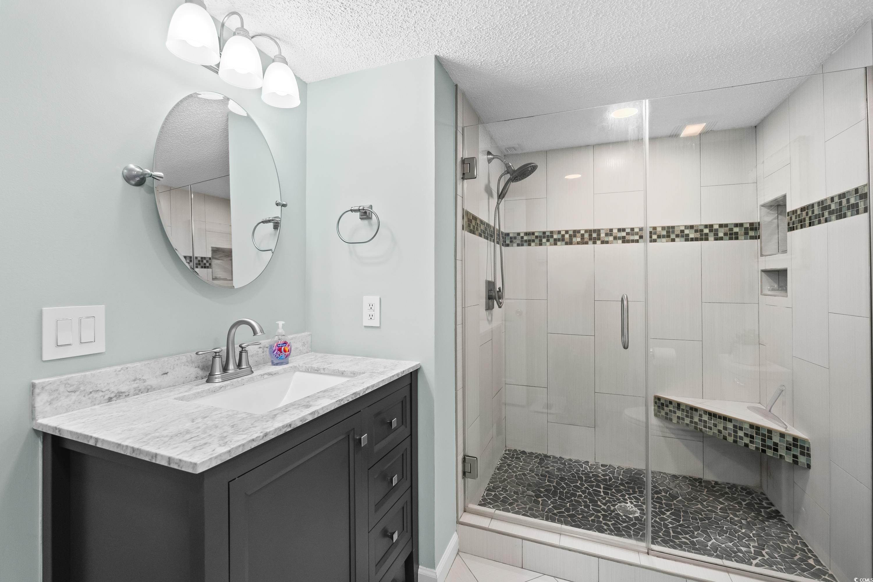 304 Cumberland Terrace, Unit 2F Myrtle Beach, SC 29572 - Photo 26 of 40 Full bath with vanity, a stall shower, and a textured ceiling