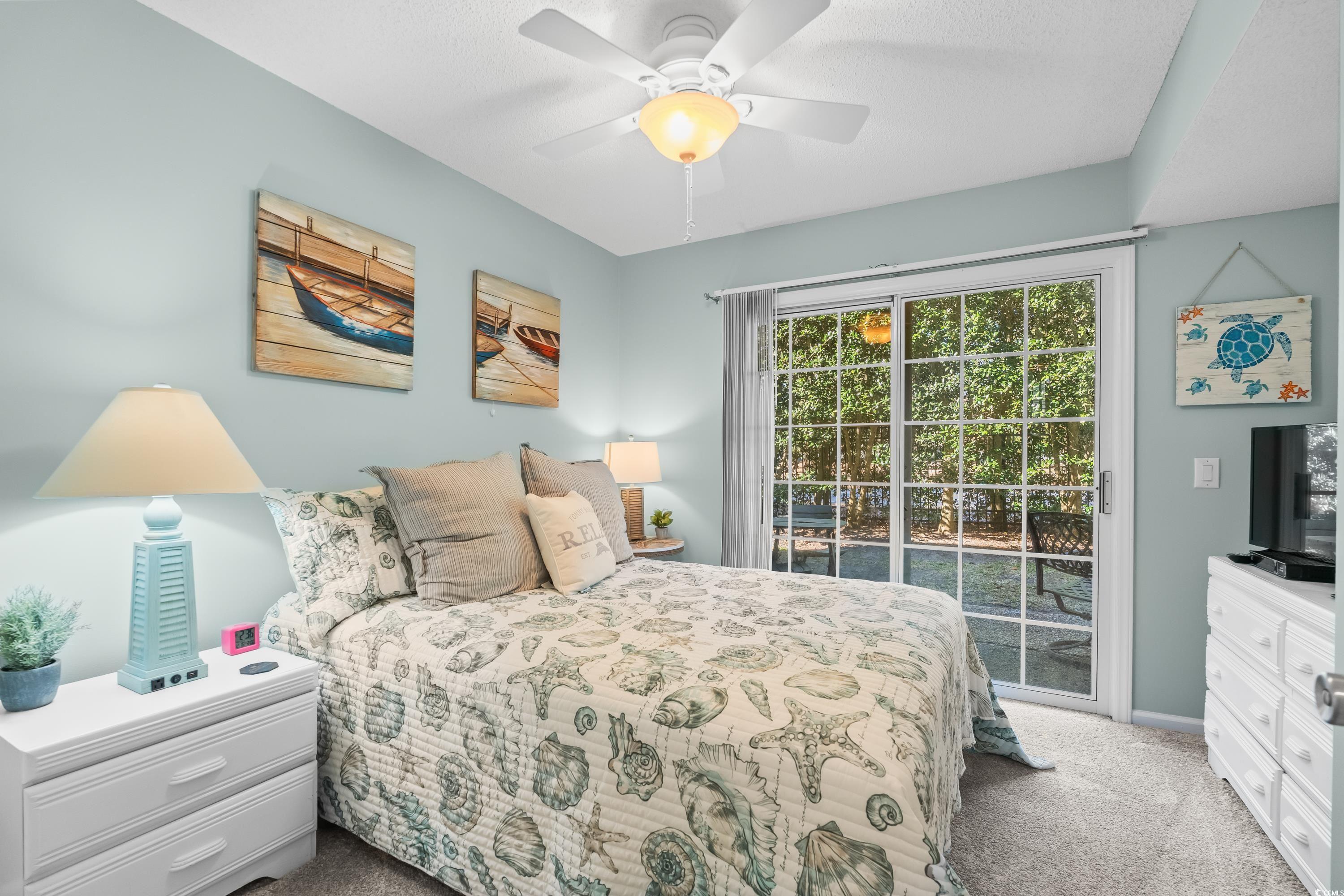 304 Cumberland Terrace, Unit 2F Myrtle Beach, SC 29572 - Photo 28 of 40 Bedroom with access to outside, light carpet, and ceiling fan