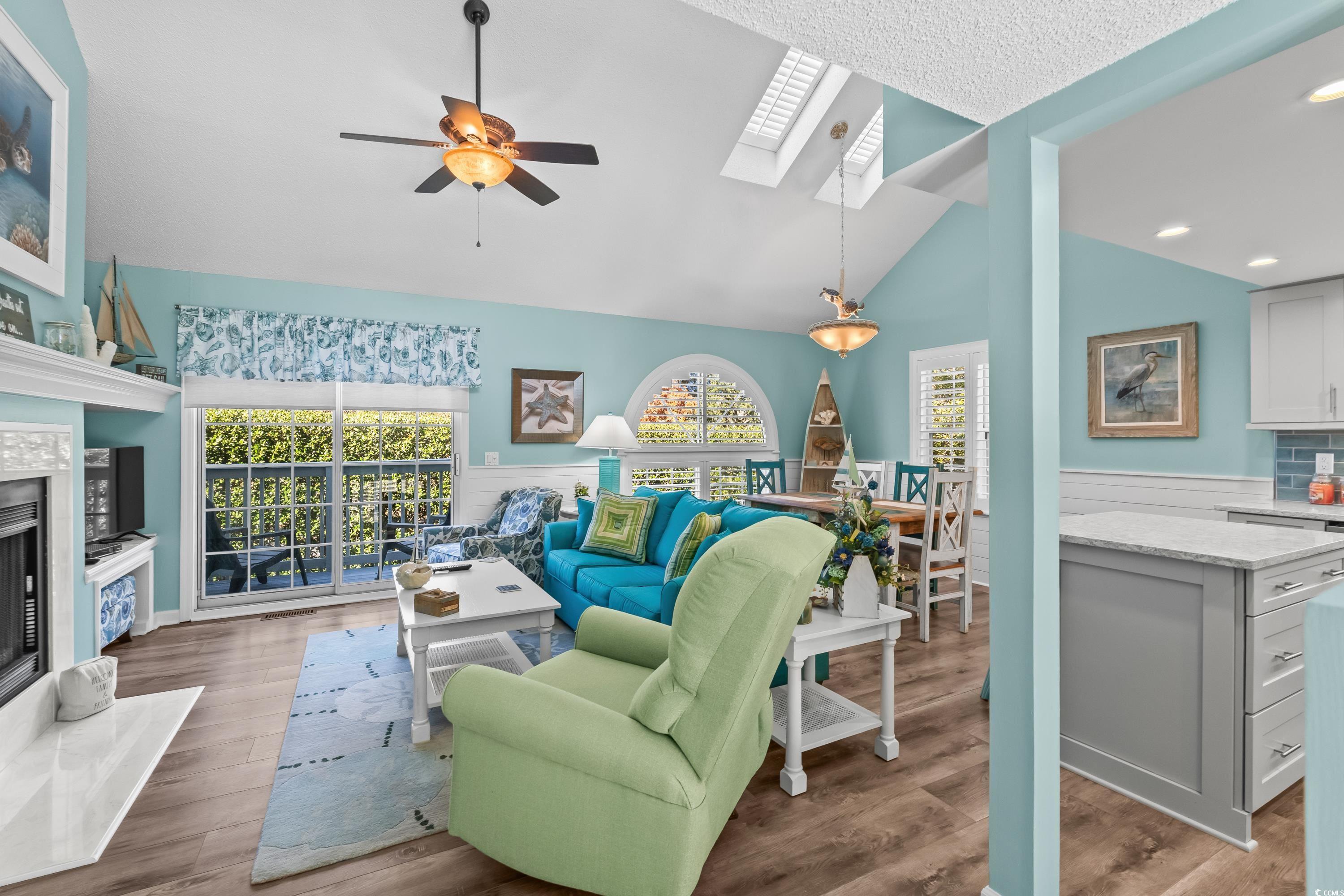 304 Cumberland Terrace, Unit 2F Myrtle Beach, SC 29572 - Photo 3 of 40 Living area with a skylight, a premium fireplace, ceiling fan, vaulted ceiling, and light wood-style flooring