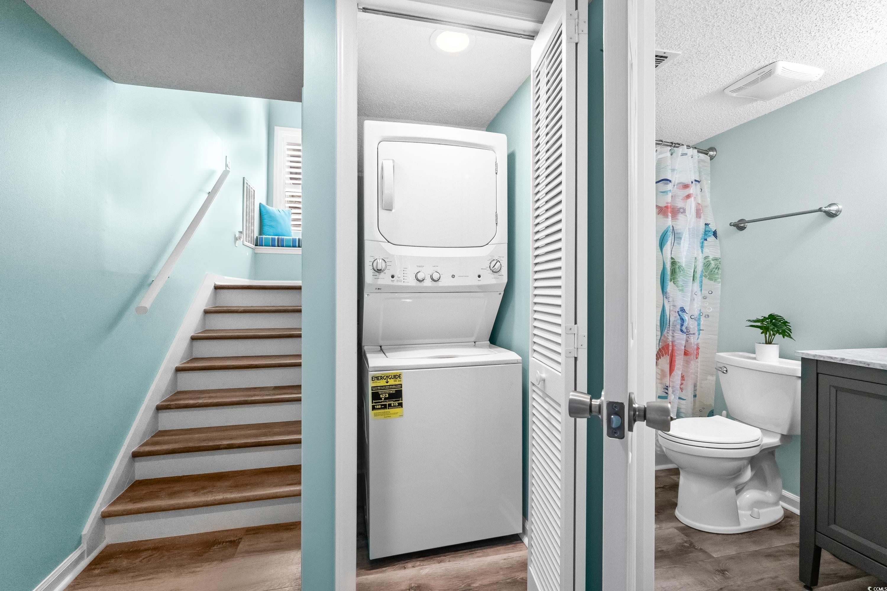 304 Cumberland Terrace, Unit 2F Myrtle Beach, SC 29572 - Photo 33 of 40 Bathroom with a shower with shower curtain, light wood-style flooring, vanity, stacked washer / dryer, and a textured ceiling
