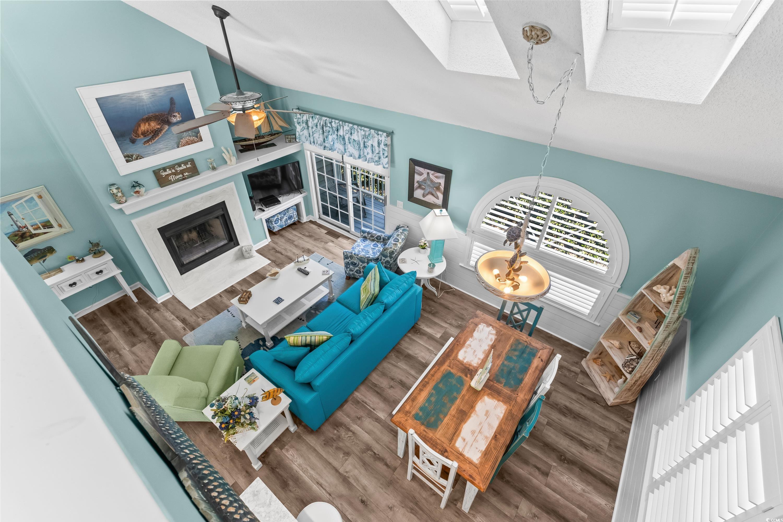 304 Cumberland Terrace, Unit 2F Myrtle Beach, SC 29572 - Photo 8 of 40 Living room featuring high vaulted ceiling, a skylight, a fireplace with flush hearth, and wood finished floors