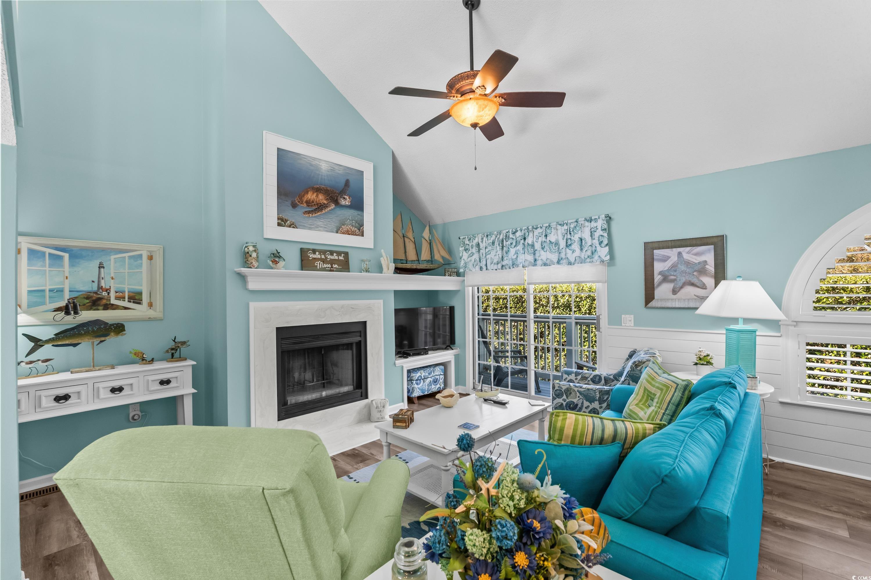 304 Cumberland Terrace, Unit 2F Myrtle Beach, SC 29572 - Photo 9 of 40 Living room featuring a fireplace, wood finished floors, a ceiling fan, wainscoting, and high vaulted ceiling
