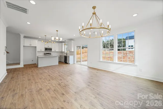 a view of a kitchen with a sink a refrigerator and a stove top oven