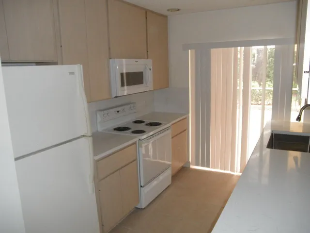 a kitchen with a refrigerator a stove a microwave and cabinets