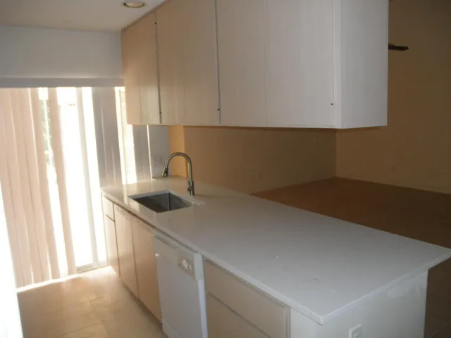a kitchen with a sink cabinets and a window