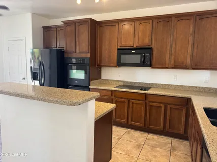 a kitchen with stainless steel appliances granite countertop wooden cabinets a refrigerator and a sink