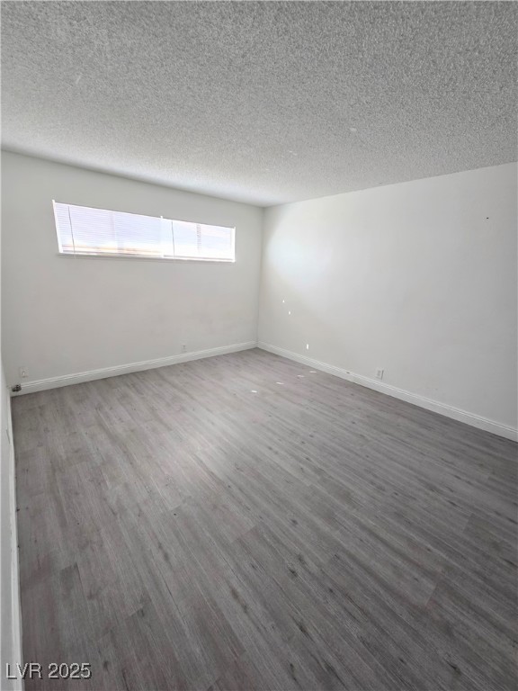 908 North Jones Boulevard, Unit B Las Vegas, NV 89108 - Photo 20 of 28 Empty room with wood finished floors and a textured ceiling
