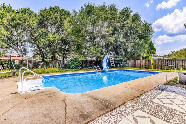 a view of a house with a backyard and a patio